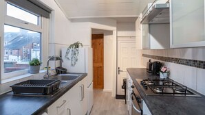 Ett modernt kök med en gasspis, en diskho och ett fönster med utsikt över stadsbilden.