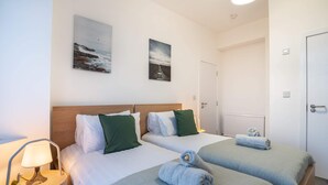 A hotel room with two beds, a nightstand with a lamp, and artwork on the walls. - 10 Mins BAE Systems -Contractor Stay -Free Parking (Barrow-in-Furness)
