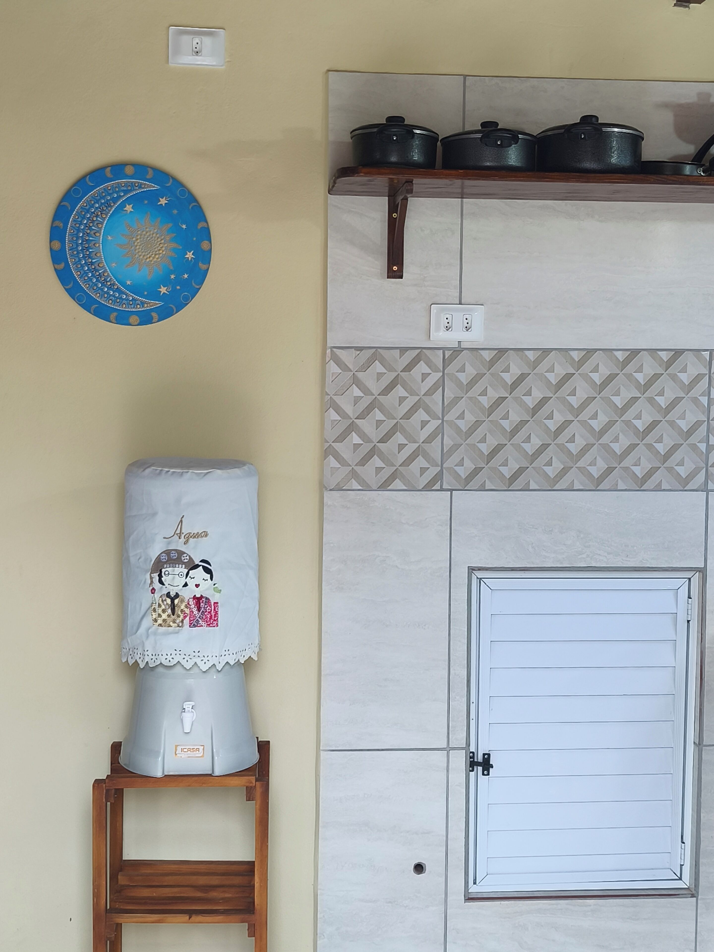 A kitchen with a white door, a sink, and a blue wall decoration.