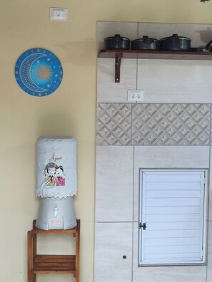 A kitchen with a white door, a sink, and a blue wall decoration. - Cozy Chalet, Your Beach Retreat (Cabo de Santo Agostinho)