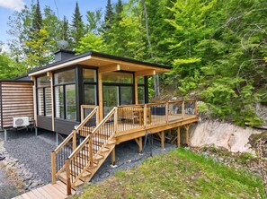 A cabin with a deck, stairs, and a satellite dish. - Cabin Retreat & Spa | La Cozy Creek Cabin (La Conception)