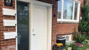 A residential building with a white door, numbered 39, and a brick facade.