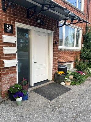 A residential building with a white door, numbered 39, and a brick facade.