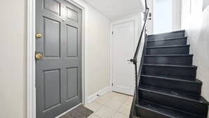 A staircase leading to a door with a doorknob and a mat at the bottom.