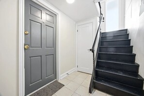 A staircase leading to a door with a doorknob and a mat at the bottom.