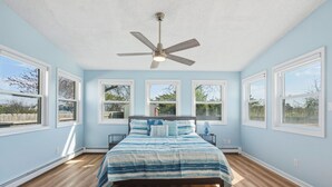 A bedroom with a bed, a ceiling fan, and large windows. - Luxury and Spacious  4-bedroom Beach house on Golf Course a Brigantine (Brigantine)