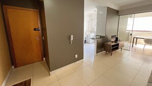 Un interior moderno con una puerta de madera, un escritorio pequeño, una silla y un espejo grande.