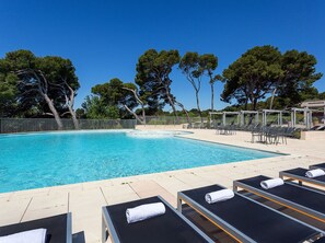 Ein Pool mit Liegestühlen und einer Pergola.