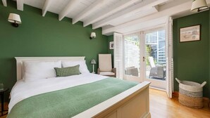 Ein Schlafzimmer mit einem Bett, einem Sessel, einer Lampe und einem Korb.