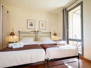 Ein Hotelzimmer mit zwei Betten, einem großen Fenster und zwei Wandleuchten.