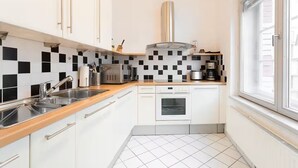 Une cuisine de taille réduite, équipée d’un évier, d’une cuisinière et d’un four à micro-ondes.