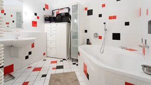 Une salle de bain moderne avec un lavabo blanc, une baignoire et une douche.