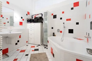 A modern bathroom with a white sink, a bathtub, and a shower. - Digital nomad Loft (Wien)