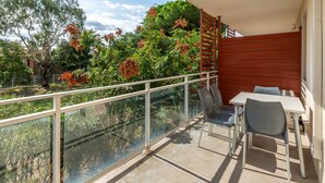 A balcony with a glass railing, a table, and two chairs. - Charmant studio à 2 km de la plage | Accès piscine (ARGELES-SUR-MER)