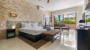 A modern bedroom with a brick wall, a bed, a bench, and a balcony with a view. - Beachfront Resort-Style Villa. Pickleball, tennis, Pools, Restaurant (Cruz de Huanacaxtle)