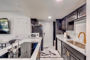 A compact kitchen with a microwave, stove, and sink. - Stylish 2BR/King Bed, Pool & Spa/Walk to Strip & UNLV (Las Vegas)