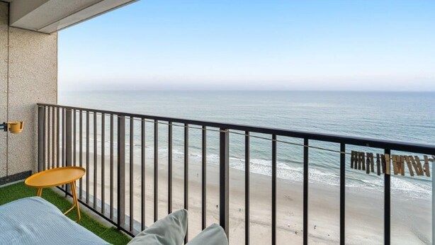 A balcony with a view of the ocean, a small table, and a chair. - Myrtle Beach Resort Renaissance Tower #2001 (Myrtle Beach)