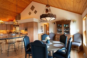 Une cuisine spacieuse dotée de meubles en bois, d’un îlot central et d’un coin repas avec une table ronde et des chaises.