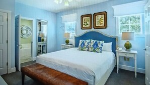 A bedroom with a bed, a bench, a ceiling fan, and two bedside tables with lamps. - Cozy 2-bedroom townhome in superb Williamsburg with AC and gym access (Williamsburg)