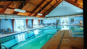An indoor swimming pool with a wooden ceiling and a view of the sky through the roof. - Cozy 2-bedroom townhome in superb Williamsburg with AC and gym access (Williamsburg)