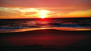 A sunset over the ocean with waves approaching the shore. - BAYSIDE FAMILY RENTAL! TWO UNITS IN ONE! (Peahala Park)