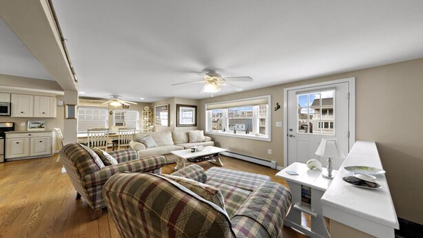A spacious living area with a sofa set, a dining table, and a kitchen area with cabinets and a microwave. - BAYSIDE FAMILY RENTAL! TWO UNITS IN ONE! (Peahala Park)