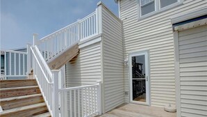 A multi-level wooden deck with white railings, a garage door, and a staircase. - BAYSIDE FAMILY RENTAL! TWO UNITS IN ONE! (Peahala Park)