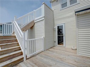 A multi-level wooden deck with white railings, a garage door, and a staircase. - BAYSIDE FAMILY RENTAL! TWO UNITS IN ONE! (Peahala Park)