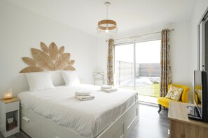 Ein Schlafzimmer mit Bett, Nachttisch und Fernseher.