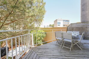 A wooden deck with a table and chairs, surrounded by a white metal railing. - Villa Viasol - superbe villa d'époque (Les Sables d'Olonne)