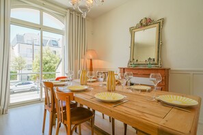 A dining room with a wooden table set for six, a chandelier, and a large mirror on the wall. - Villa Viasol - superbe villa d'époque (Les Sables d'Olonne)