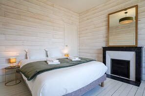 A bedroom with a bed, bedside lamps, a mirror, and a fireplace. - Villa Viasol - superbe villa d'époque (Les Sables d'Olonne)
