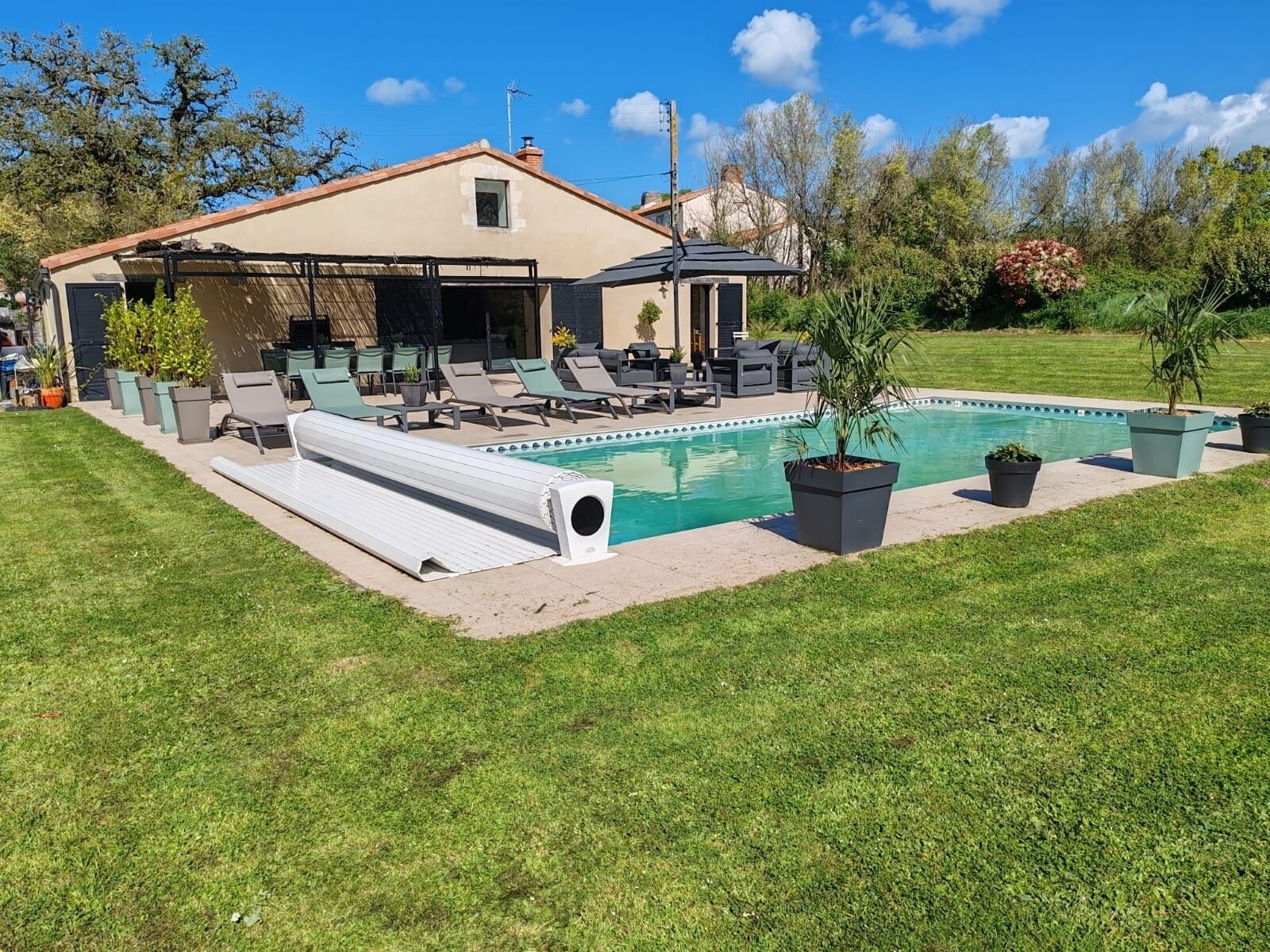 A house with a swimming pool, outdoor seating, and a covered patio area.