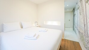 A hotel room with a large bed, a bedside table, a ceiling fan, and a mural on the wall. - Beluga - pied-à-terre idéal sur la côte vendéenne (Les Sables d'Olonne)