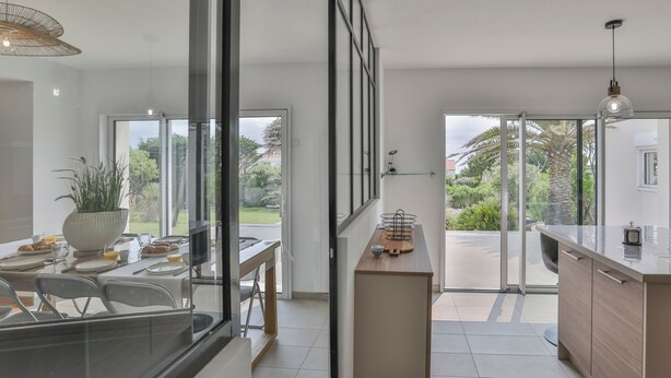 A modern kitchen with a dining area, large windows, and a view of the outdoors. - Villa Mediterranée - Three Bedroom House, Sleeps 8 (Les Sables d'Olonne)