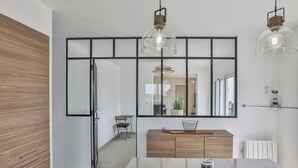 A modern kitchen with a large island, pendant lights, and a mirrored backsplash. - Villa Mediterranée - Three Bedroom House, Sleeps 8 (Les Sables d'Olonne)
