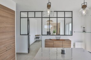 A modern kitchen with a large island, pendant lights, and a mirrored backsplash. - Villa Mediterranée - Three Bedroom House, Sleeps 8 (Les Sables d'Olonne)