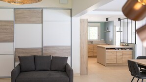 Un salon moderne avec un canapé, une table à manger et des chaises, et un coin cuisine en arrière-plan.