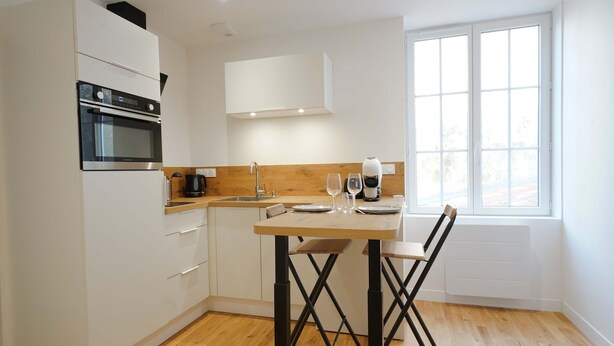 A compact kitchen with a built-in oven, a coffee maker, and a window with a view. - Les Halles Sablaises (Les Sables d'Olonne)