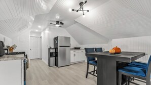 Een moderne keuken met een eethoek, witte wanden en een schuine nok.
