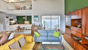 Un amplio salón con sofá, mesa de centro y aparador de madera.