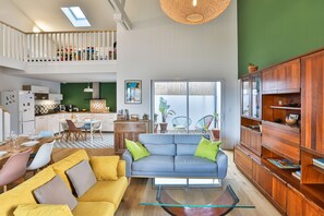 A spacious living area with a sofa, coffee table, and wooden cabinet. - La Bulle - Maison classée 4* (Brem-sur-Mer)