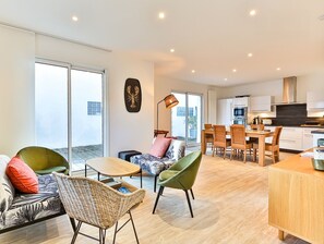 Ein modernes Apartment mit Essbereich, Küche und großen Fenstern.