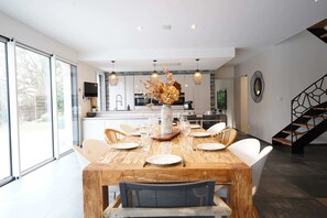 A modern kitchen with a dining area. - Villa du Château - vue imprenable sur le château médiéval (Talmont-Saint-Hilaire)