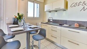 Una cocina moderna con comedor, que incluye una mesa preparada para dos personas, una ventana y una encimera con fregadero.