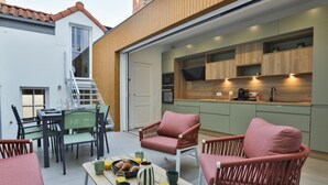 An outdoor dining area with a table set for breakfast, chairs, and a staircase leading to a second floor. - Villa Babil - Four Bedroom House, Sleeps 8 (Les Sables d'Olonne)