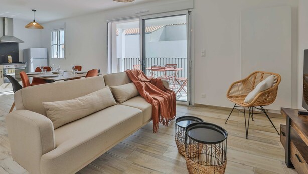 Un soggiorno moderno con divano, tavolo da pranzo, sedie e un balcone con vista.