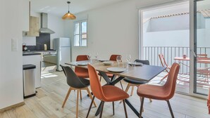 Una cucina moderna con zona pranzo, un balcone con vista e un'ampia finestra.