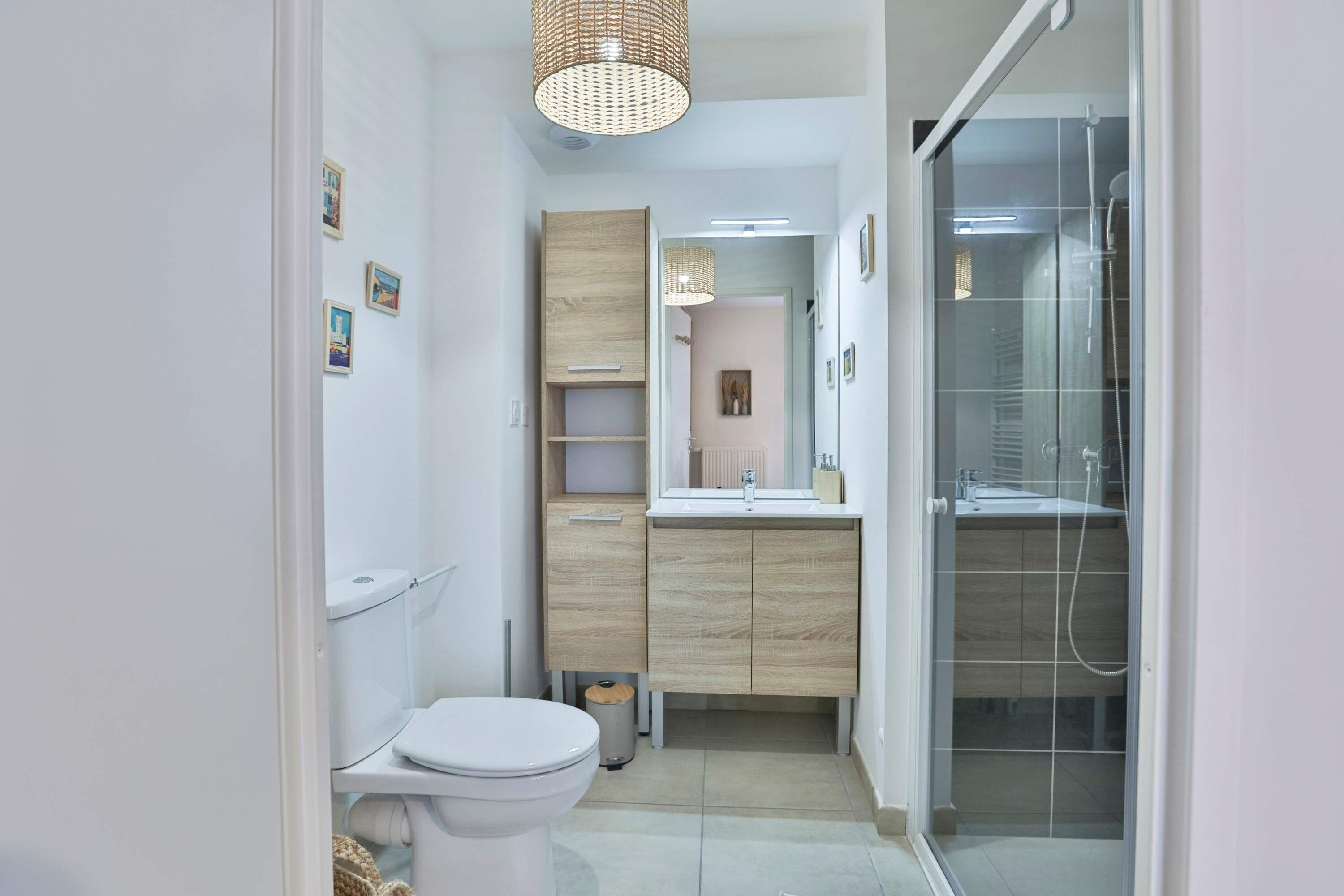 Een moderne badkamer met toilet, wastafel en douche.
