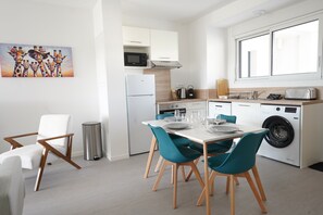 A modern kitchen with white cabinets, a microwave, a toaster, and a washing machine. - Clos des Sables B13 - Two Bedroom Apartment, Sleeps 4 (Les Herbiers)